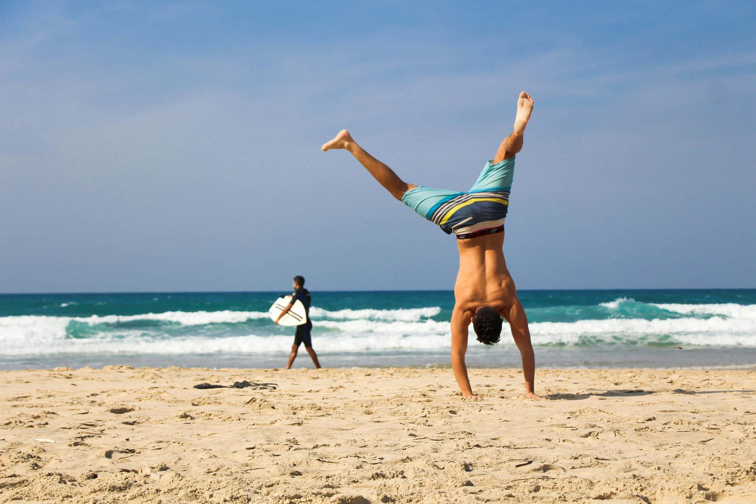 man doing cartwheel at the beach